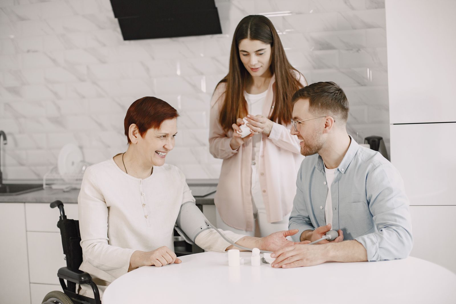 A DediCare placement coordinator and a caregiver talking with two adult siblings and their mother during a care-home visit